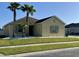 Charming home featuring palm trees, a well-manicured lawn, and neutral-toned exterior at 2864 Running Brook Cir, Kissimmee, FL 34744