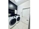 Laundry room with a modern washer and dryer set and geometric wallpaper at 2864 Running Brook Cir, Kissimmee, FL 34744