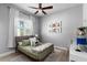Bedroom featuring a fan, pictures, window and bed with a comfortable pillow and comforter at 3249 Pearly Dr, Lakeland, FL 33812