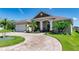 Charming single-Gathering home featuring a brick paved driveway, two car garage, and tropical landscaping at 3249 Pearly Dr, Lakeland, FL 33812