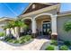 Inviting entrance with double-door entry, framed by arched columns and tropical landscaping at 3249 Pearly Dr, Lakeland, FL 33812