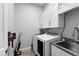 Well-organized laundry room features a sink, modern washer and dryer, and convenient storage cabinets at 3249 Pearly Dr, Lakeland, FL 33812