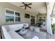 Comfortable furnished screened-in patio featuring an outdoor lounge area and dining area with multiple ceiling fans at 3249 Pearly Dr, Lakeland, FL 33812