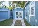 View of blue detached garage and additional out-building with white french doors in the home's backyard at 549 Palencia Pl, Lakeland, FL 33803