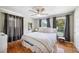 Inviting primary bedroom with hardwood floors, natural light from two windows, and neutral colored bedding at 549 Palencia Pl, Lakeland, FL 33803