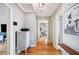 Hallway with hardwood floors and neutral walls showcases a dresser, decor, and doorways to other rooms at 549 Palencia Pl, Lakeland, FL 33803