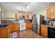 Functional kitchen with stainless steel appliances, wood cabinets, and ample counter space for efficient cooking at 549 Palencia Pl, Lakeland, FL 33803