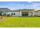 A spacious backyard features lush lawn and a covered patio, perfect for entertaining at 6068 Sacred Oak Ave, Mount Dora, FL 32757