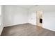 Light and airy bedroom with wood-look floors and view to ensuite bathroom at 6068 Sacred Oak Ave, Mount Dora, FL 32757
