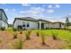 New home with sodded lawn, mulched landscape, and covered lanai at 6068 Sacred Oak Ave, Mount Dora, FL 32757