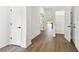 Bright hallway with modern flooring, white walls, black hardware, and doorways leading to other rooms at 6068 Sacred Oak Ave, Mount Dora, FL 32757