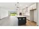 Modern kitchen featuring a large island, white cabinets, stainless steel appliances, and an open layout at 6068 Sacred Oak Ave, Mount Dora, FL 32757