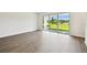 Open living space featuring wood-look floors and a sliding glass door showcasing the backyard view at 6068 Sacred Oak Ave, Mount Dora, FL 32757