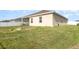 Lush backyard showcasing a spacious lawn and modern home exterior, complete with white fencing at 887 Galloway St, Lake Alfred, FL 33850