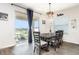 Bright dining area featuring a rustic table, modern lighting fixture, and sliding glass doors at 887 Galloway St, Lake Alfred, FL 33850