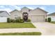 Charming single-story home featuring manicured lawn, a two-car garage, and a decorative front door wreath at 887 Galloway St, Lake Alfred, FL 33850