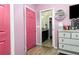 A pink hallway leads to a well designed bathroom with a dark vanity at 887 Galloway St, Lake Alfred, FL 33850