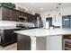 Modern kitchen with dark cabinetry, stainless steel appliances, granite countertops, and an island at 887 Galloway St, Lake Alfred, FL 33850