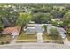 An aerial view of a quaint home featuring a long driveway and bordered by a charming white fence at 446 Eagle Cir, Casselberry, FL 32707