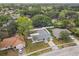 An aerial shot shows a charming house, surrounded by trees and a white fence at 446 Eagle Cir, Casselberry, FL 32707