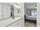 Bathroom with a white sink, mirror, cabinet and an adjacent bedroom at 446 Eagle Cir, Casselberry, FL 32707