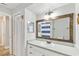 Bathroom features a wood framed mirror, white cabinets, and a shower behind a striped curtain at 446 Eagle Cir, Casselberry, FL 32707