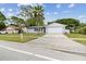 Charming single-story home with attached garage, a well-manicured lawn, and a palm tree at 446 Eagle Cir, Casselberry, FL 32707