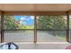 This screened-in balcony overlooks the tennis court and offers serene views of the surrounding landscape at 886 Suffolk Pl, Davenport, FL 33896
