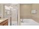 Bright bathroom features a soaking tub, glass enclosed shower, and neutral color palette at 886 Suffolk Pl, Davenport, FL 33896
