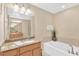 Bright bathroom features a soaking tub, granite countertop, and neutral color palette at 886 Suffolk Pl, Davenport, FL 33896