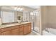 Bright bathroom with a glass-enclosed shower, soaking tub, and dual sink vanity at 886 Suffolk Pl, Davenport, FL 33896