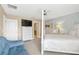 Spacious bedroom features a blue sofa, flatscreen TV, and a view into an ensuite bathroom at 886 Suffolk Pl, Davenport, FL 33896