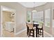 Bright breakfast nook featuring a table for four, surrounded by windows, next to the laundry area at 886 Suffolk Pl, Davenport, FL 33896