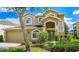 Two-story home with a front lawn, large windows, and a two-car garage, showcasing classic curb appeal at 886 Suffolk Pl, Davenport, FL 33896