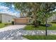 Charming home featuring a well-manicured lawn, a two-car garage, and mature trees providing shade at 886 Suffolk Pl, Davenport, FL 33896