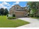 Two-story home showcasing a spacious driveway, a well-maintained lawn, and an attached two-car garage at 886 Suffolk Pl, Davenport, FL 33896