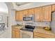 Kitchen featuring stainless steel oven and microwave, with granite countertops and wood cabinets at 886 Suffolk Pl, Davenport, FL 33896