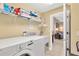 Functional laundry room with modern appliances, storage shelves, and a utility sink, conveniently located near living area at 886 Suffolk Pl, Davenport, FL 33896