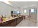 Bright bathroom featuring a double sink vanity and a glass-enclosed shower at 890 Marisa Ln, Kissimmee, FL 34744
