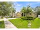 Well-kept single Gathering home with an attached two car garage, green lawn, and mature trees in a suburban neighborhood at 890 Marisa Ln, Kissimmee, FL 34744