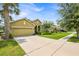 Inviting one-story home boasts a two-car garage, lush lawn, and a well-maintained exterior on a sunny day at 890 Marisa Ln, Kissimmee, FL 34744