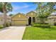 Charming single-story home featuring lush green lawn, a two car garage, and a well manicured front yard at 890 Marisa Ln, Kissimmee, FL 34744