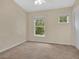 Neutral bedroom featuring carpet, fan and two windows with natural light at 12975 Calderdale Ave, Windermere, FL 34786