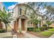 Inviting townhome featuring a covered entry, neutral tones, and lush green landscaping at 12975 Calderdale Ave, Windermere, FL 34786