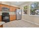 Well-equipped kitchen with stainless steel refrigerator, range, and plenty of natural light at 12975 Calderdale Ave, Windermere, FL 34786