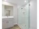 Stylish bathroom with glass shower, white textured tile, and a gray vanity at 9619 Sw 62Nd Ct, Ocala, FL 34476