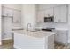 Modern kitchen features white cabinets, stainless steel appliances, gray countertops and an island with a sink at 9619 Sw 62Nd Ct, Ocala, FL 34476