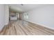 Bright and airy living room with wood-look floors and view of modern kitchen in the background at 9619 Sw 62Nd Ct, Ocala, FL 34476