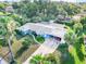 Charming single-story home with a bright yellow door, carport, screened-in patio and mature tropical landscaping at 1910 Sylvester Ct, Lakeland, FL 33803