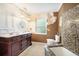 Traditional bathroom with a dark wood vanity, tile flooring, and natural light from the window at 1910 Sylvester Ct, Lakeland, FL 33803